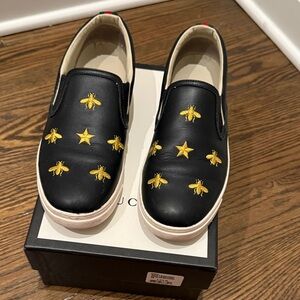 Gucci Black Slip-Ons with Gold Motifs